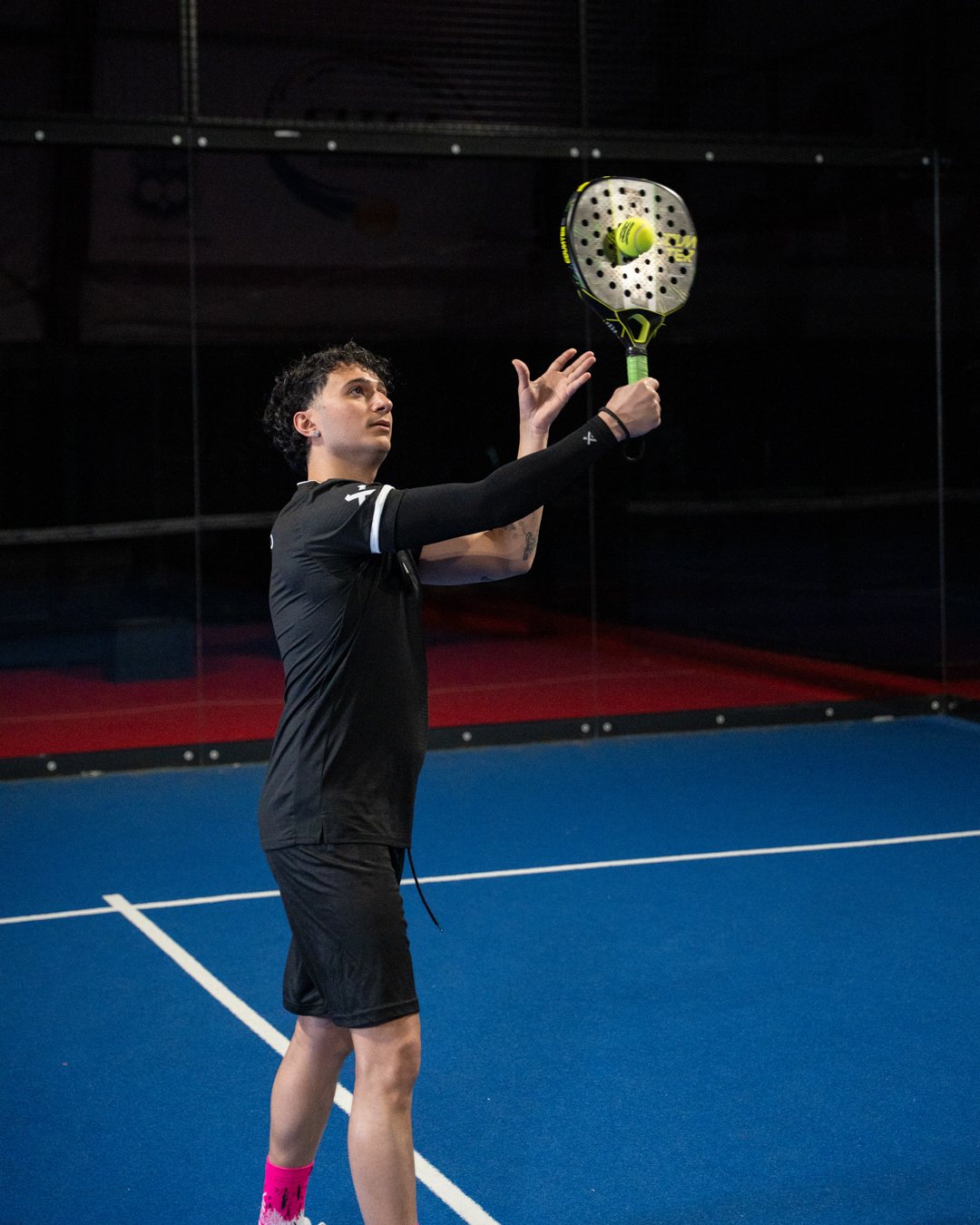 Padel-Spieler bereitet einen Smash mit schwarzer Arm Sleeve vor