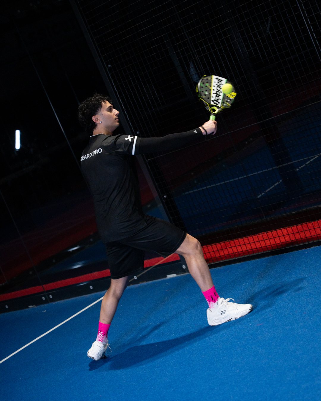 Padel-Spieler beim hohen Schlag mit schwarzer Arm Sleeve